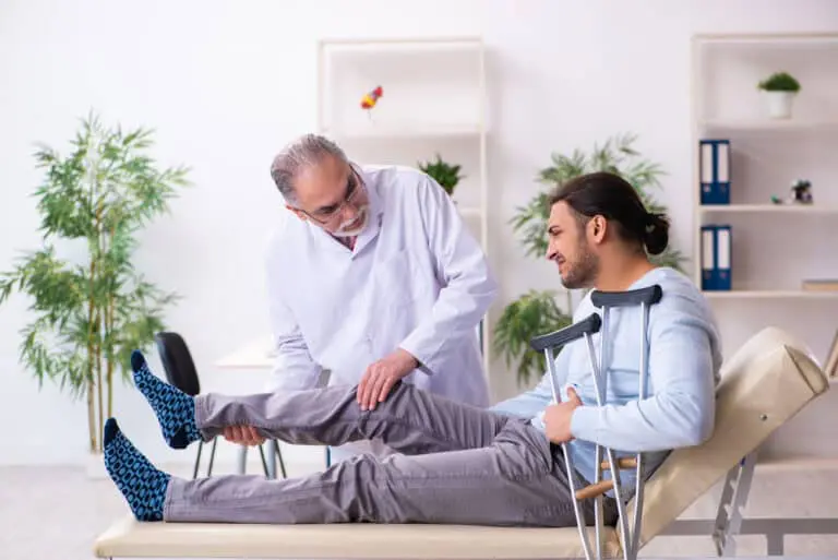 Young leg injured man visiting old doctor