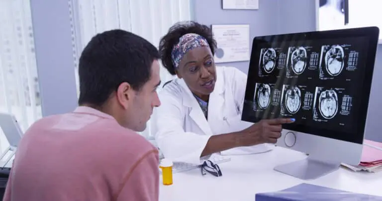 doctor and patient looking at brain scans on computer